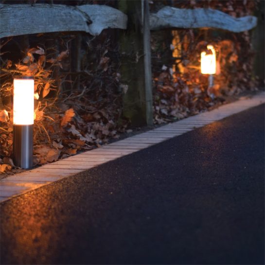 Bollard lights at night against an autumn garden